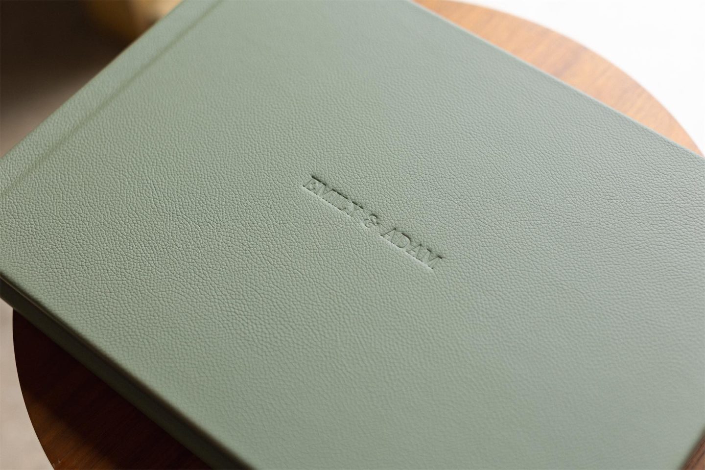A jade green leather bound matted album with embossed cover text