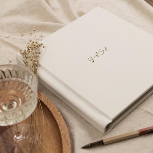 Bespoke bound guest book in leather with gold foiling on a cloth cover table