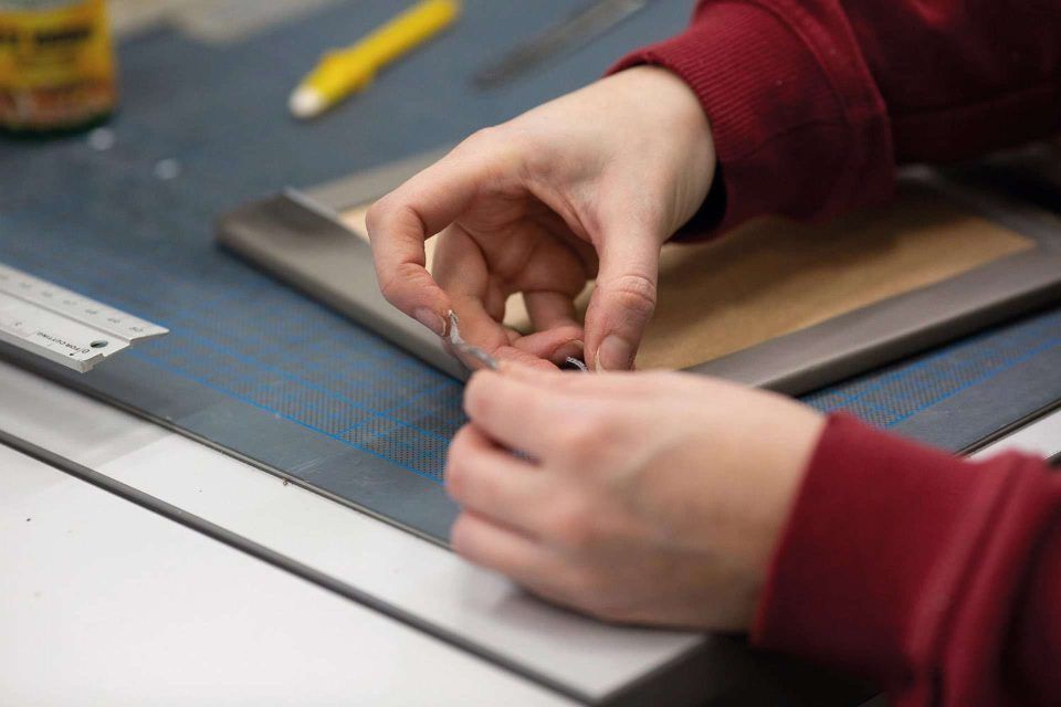 A Folio book bonder handcrafting the leather photo album cover in the UK