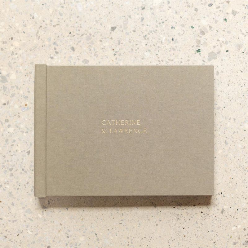 A landscape format wedding album from Folio Albums sitting on a marble counter and viewed from above with wedding album personalisation options