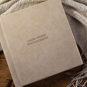 A sandstone coloured leather bound matted album photo book with engraved cover text for a portrait shoot