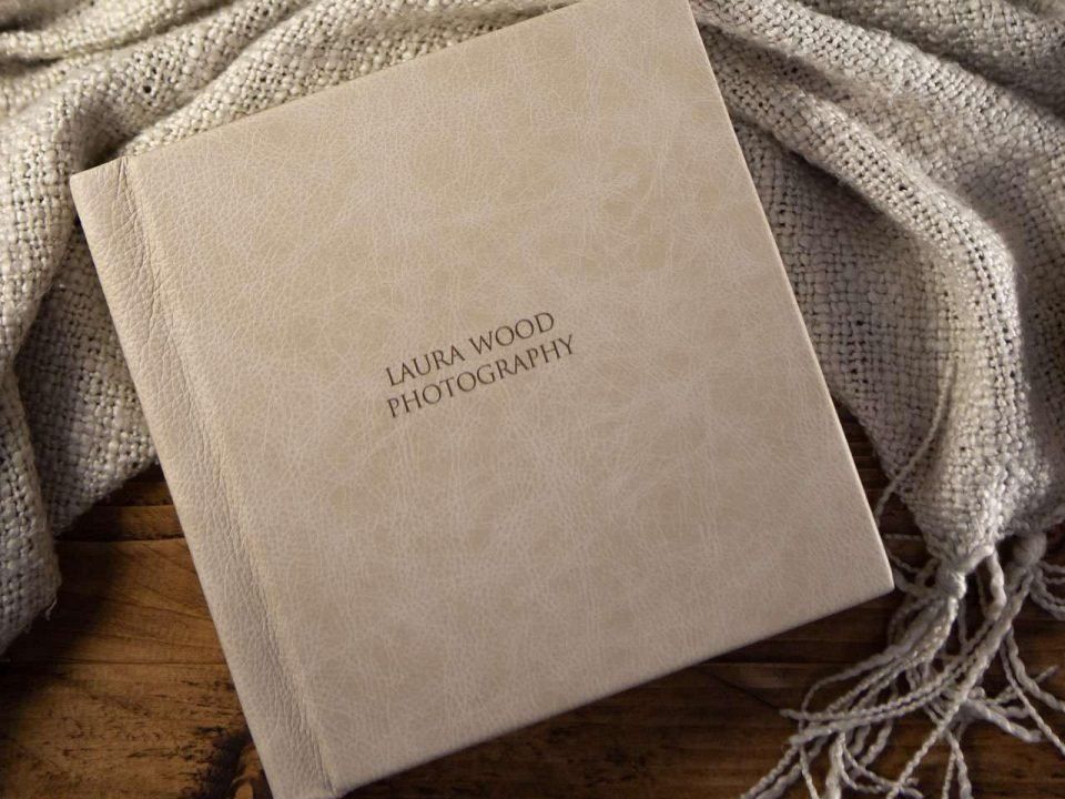 A sandstone coloured leather bound matted album photo book with engraved cover text for a portrait shoot