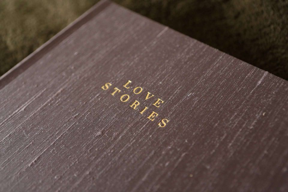 A matted photo album covered in silk material with gold foiled text