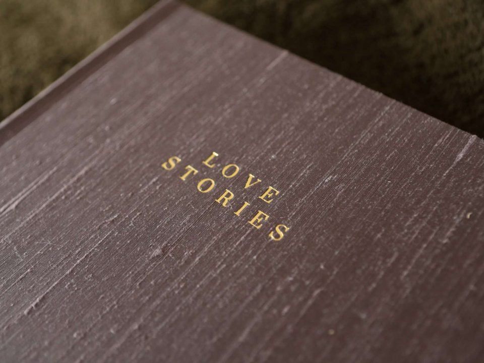 A matted photo album covered in silk material with gold foiled text
