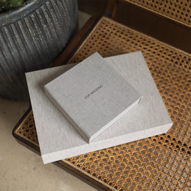 Two fabric covered clamshell style boxes stacked on top of one another