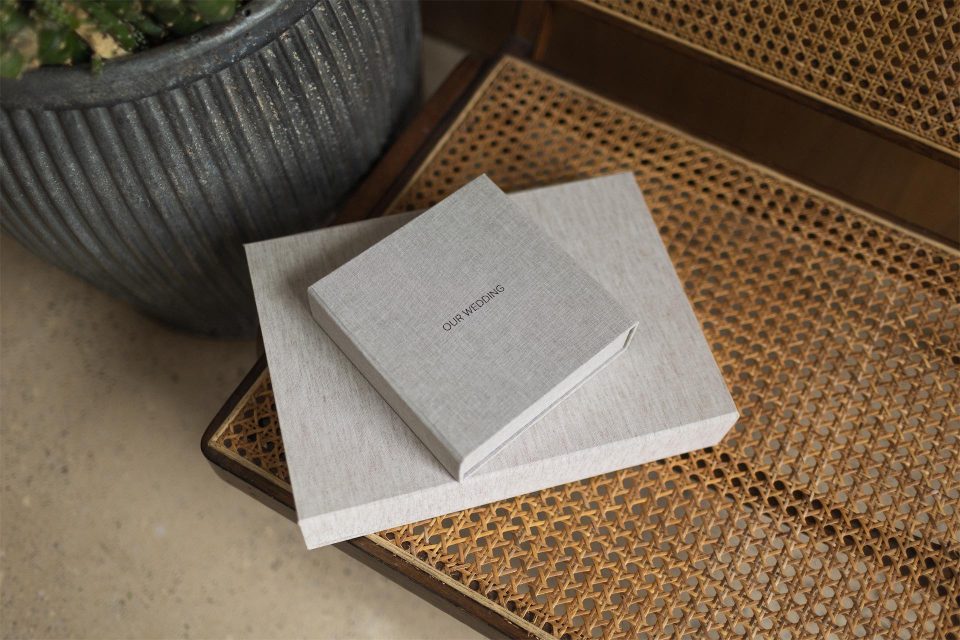Two fabric covered clamshell style boxes stacked on top of one another