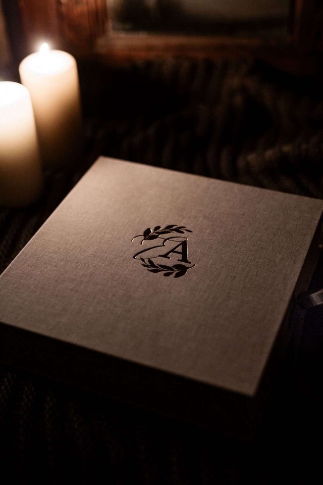 Warm lighting on a clamshell box with a photographer's studio logo on the lid