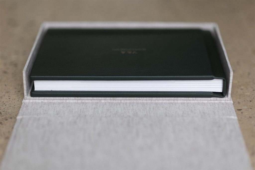 A side shot showing a wall construction of a handmade clamshell box from Folio with a leather album inside