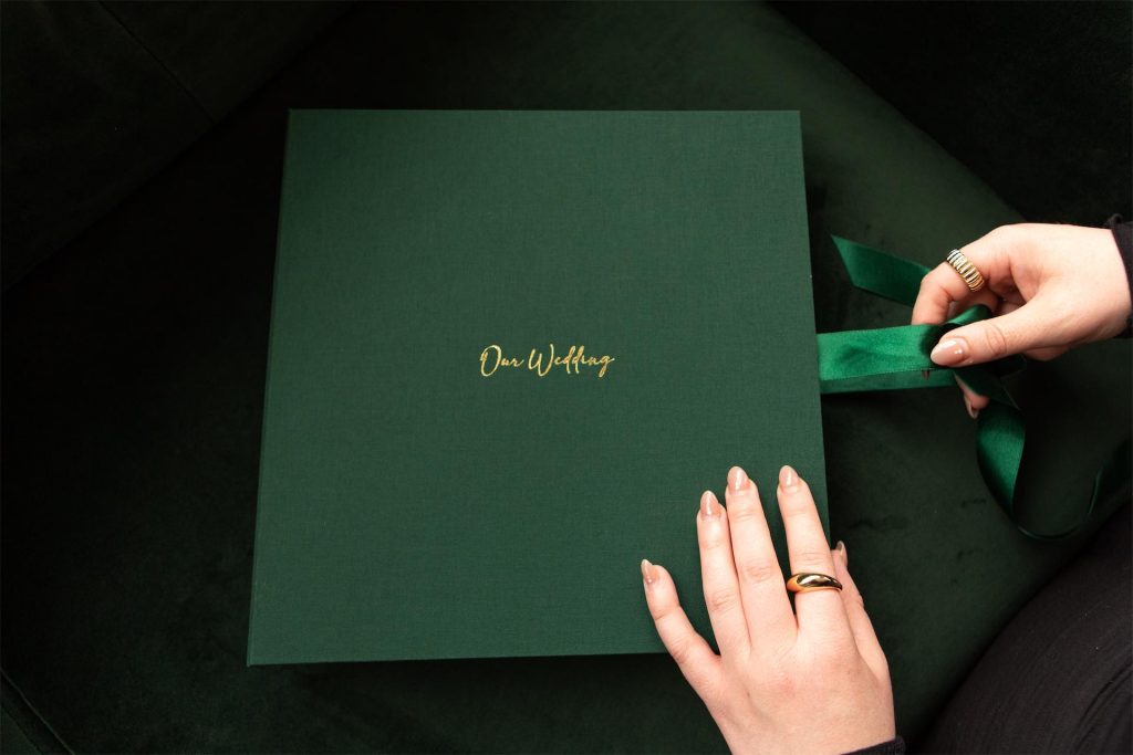 Someone opening the ribbon box of a Folio luxury clamshell box