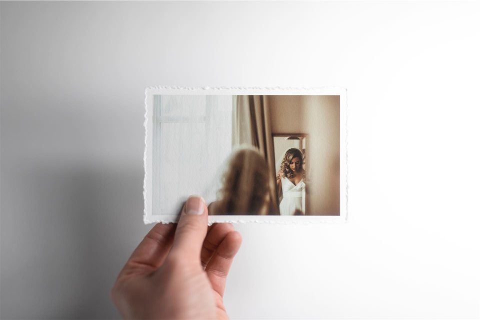 A hand holding a fine art print with a deckle edge