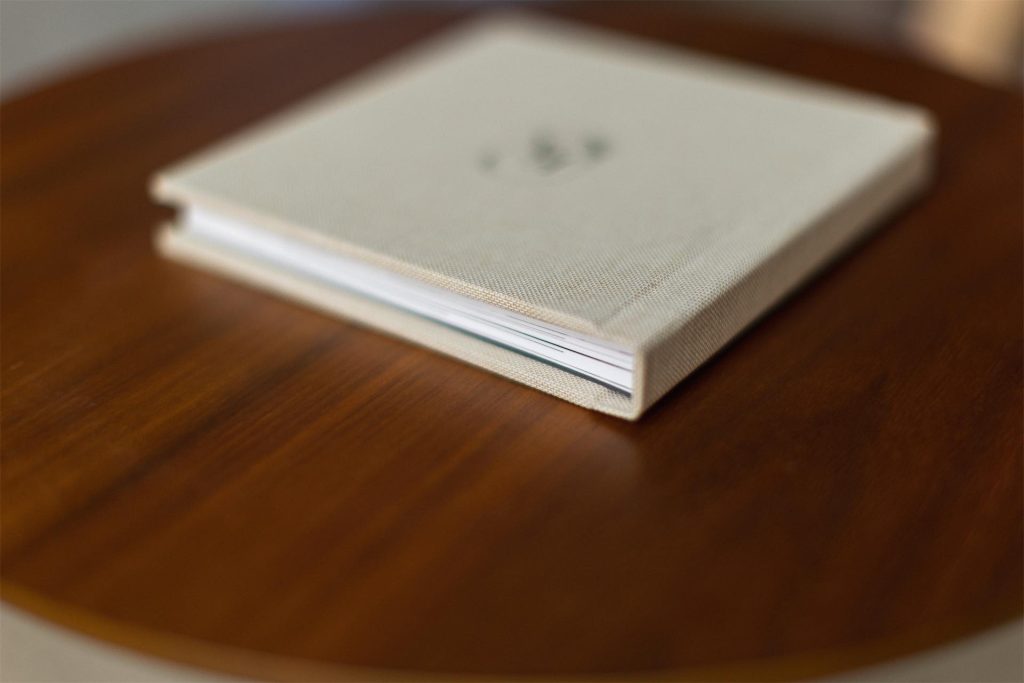 A fabric covered mini copy on a table with black cover printed personalisation
