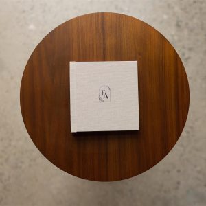 A fabric covered mini album with cover personalisation in black on a table