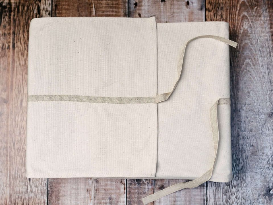 A photo book matted album in a natural cotton wrap and a ribbon tie
