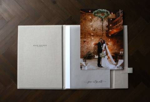 A handmade luxury print folder open in a table with fine art prints