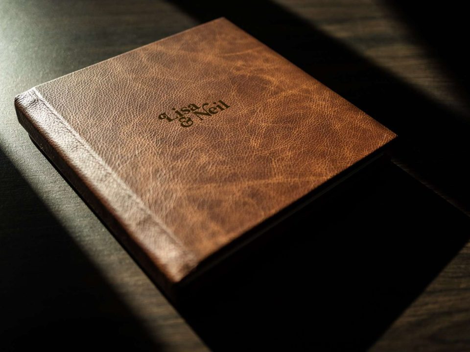 A vintage saddle leather photo album with gold foiled bespoke logo on the cover handmade in the UK