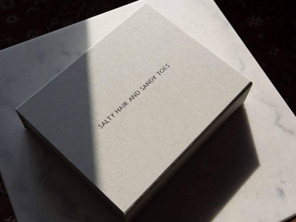 A fabric covered handmade box made to hold matted prints with a lid personalised with text