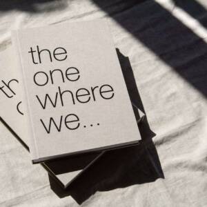 A coffee table A4 photo book and slipcase stacked on top of each other with strong shadows cast across the image