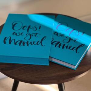 A blue slipcase and photo book on a round coffee table