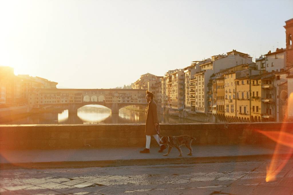 Stefano Santucci walking his dog along a bridge in Florence, Italy.
